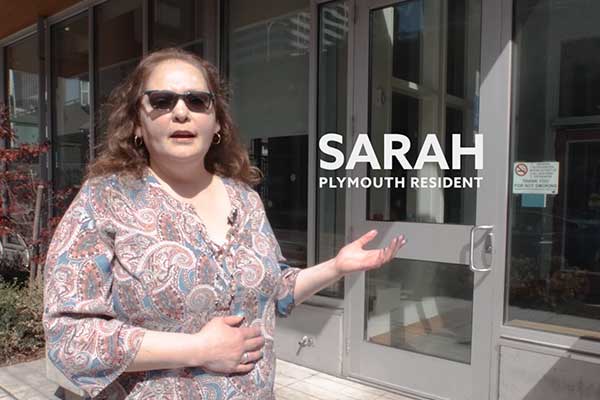 Sarah, a Plymouth resident standing in front of her building