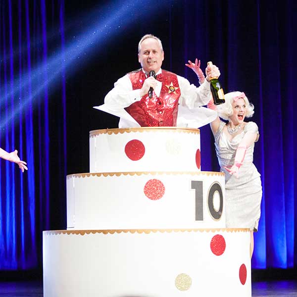 Paul Lambros hops out of a cake for Seattle Dances' 10th anniversary