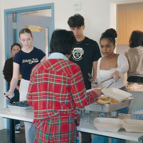 Students from the Bush School serve a meal at Plymouth's building Toft Terrace