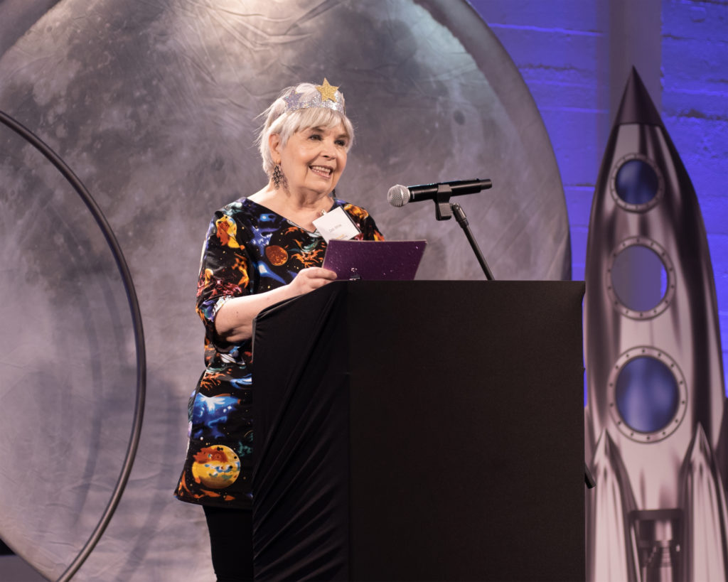 A woman confidently delivering a speech to an attentive audience, expressing her thoughts and ideas with passion and conviction.