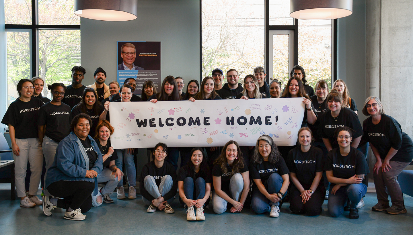 Nordstrom volunteers pose with welcome sign