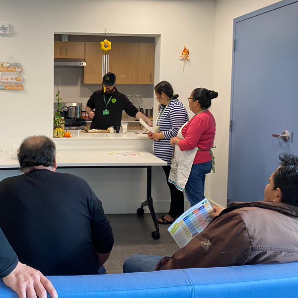 A volunteer leads a cooking class with Plymouth Housing residents