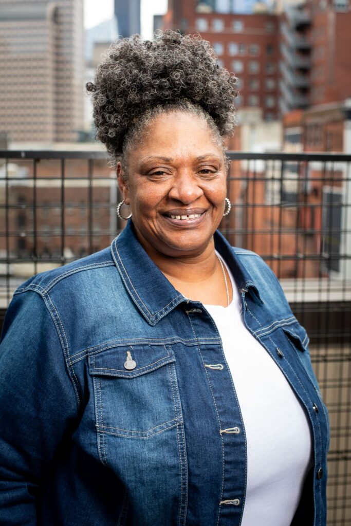 A woman standing outside on a roof deck of a Plymouth Housing building