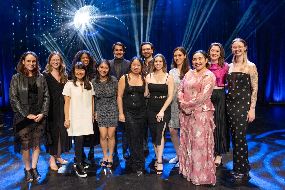 Group of people in formal dress on a stage with disco ball lighting